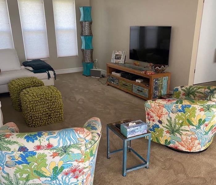 Living room with chairs on wet carpet